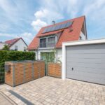 Mülltonnenboxen vor einer Garageneinfahrt