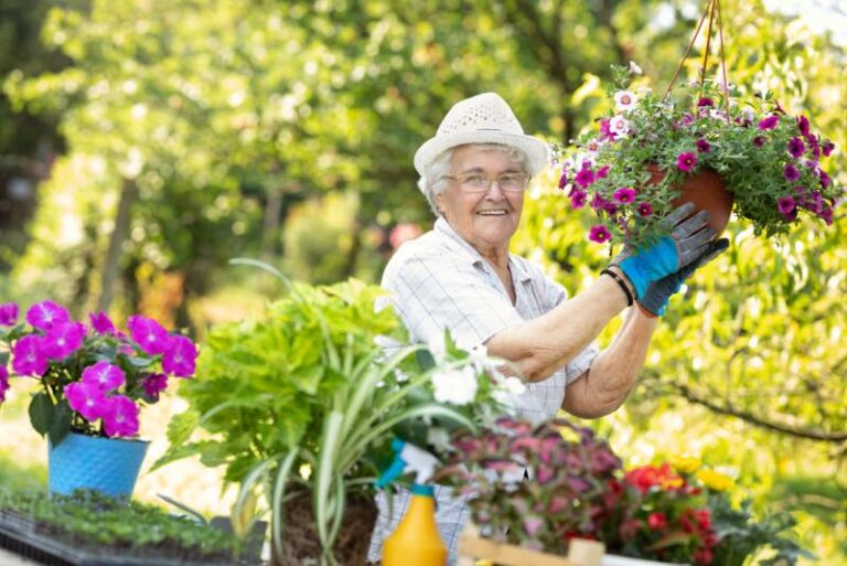 Seniorin bepflanzt eine Blumenampel